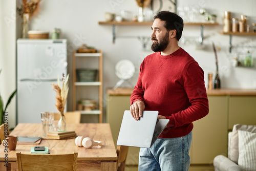 Foto Handsome adult man enjoying a cozy moment at home while holding a laptop