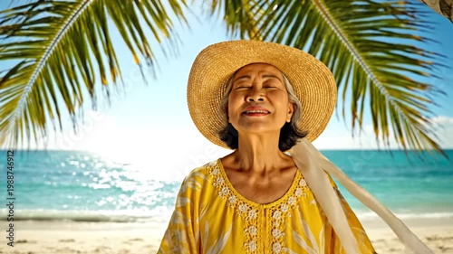 Smiling senior Asian woman on tropical beach under palm tree