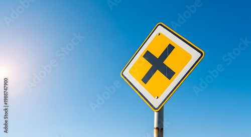 Yellow road sign with black cross on blue sunny background. Generative AI