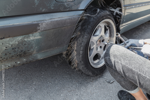 Damaged car wheel lies twisted near roadside