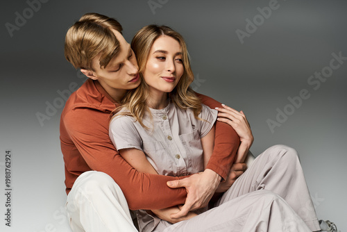 Fotografie Young couple embracing in stylish spring outfits during a cozy studio moment