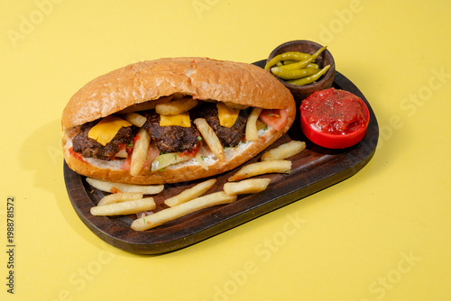 Kofta doner kebab on wooden tray isolated on yellow background
