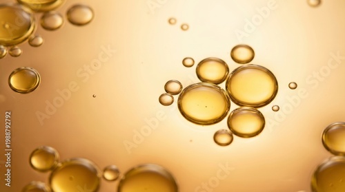 Golden oil bubbles floating on a warm liquid surface with a soft gradient background