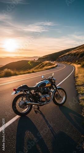 Classic motorcycle parked on scenic winding road at sunset