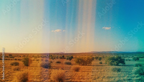 A vast, arid desert landscape stretches under a bright blue and golden sky, featuring sparse vegetation and a vintage-like film texture.