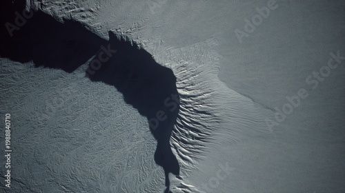 sinuous. A stunning aerial view from space of a massive, sinuous sand dune resembling a slug, dramatically cutting through a textured floodplain landscape. travel magazines.
