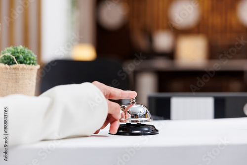 Fotografie Reception bell being rung by tourist during stay at modern hotel