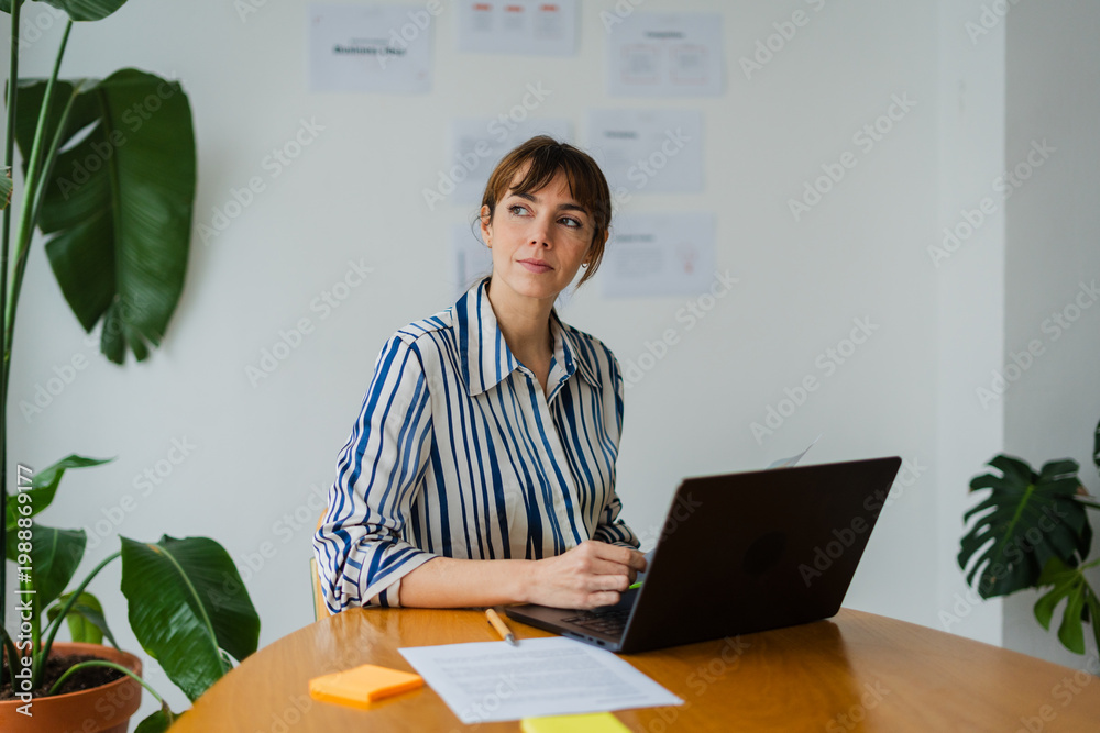 © Nuria Seguí/Stocksy - Elegant woman works on her laptop