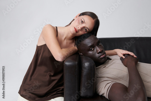 Cool couple at sofa in modern studio