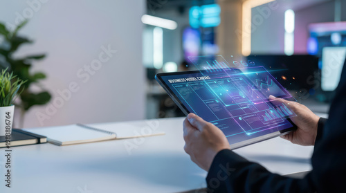 Business model on futuristic transparent tablet screen held by person in modern office with blurred background and digital interface