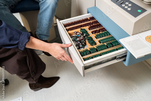 Optician opening trial lens set drawer for eye exam
