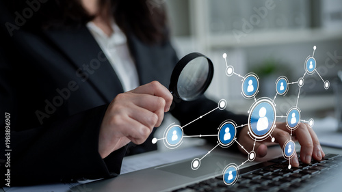 Принти на полотні A business professional conducts thorough analysis of digital networking connections using a magnifying glass while working on a laptop in a modern office environment