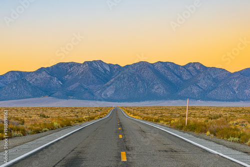Bild auf Leinwand Perspective view of an empty highway (Benton Crossing Road) stretching toward the Sierra Nevada mountains near Hot Creek at sunset