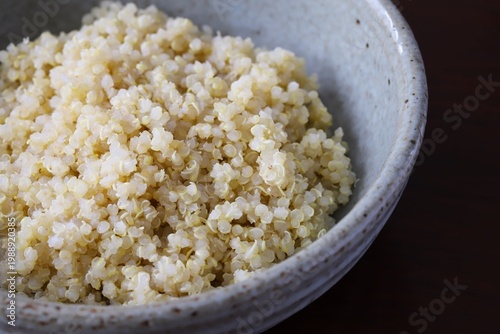 A close up shot of some freshly cooked quinoa in Japanese style food bowl on wooden table