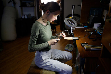 a woman makes jewelry