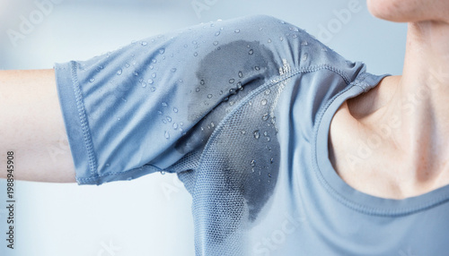 Close-up of woman's blue t-shirt showing sweat stains under armpit.