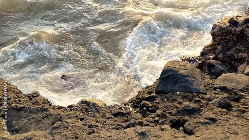 A spotlight on the waves crashing against the rocks