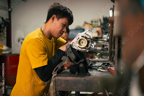 Mechanic repairing vehicle alternator, providing professional