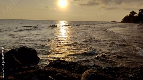 Calm ocean waves with a beautiful sunset reflecting on the water