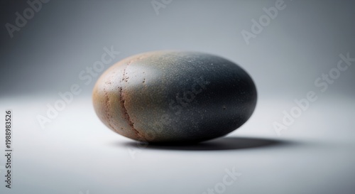 A single smooth river rock displaying a beautiful gradient of natural earth tones and subtle