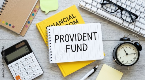 A provident fund notebook with calculator and financial books on a wooden office desk