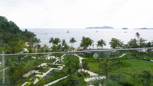 photo of a green garden landscape, lots of coconut trees with a view of the sea and islands, a fresh atmosphere at a resort in Indonesia
