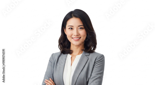 Professional Asian woman in a gray suit, with arms crossed, smiling confidently at the camera on a white background, conveying competence and approachability in a business or corporate setting