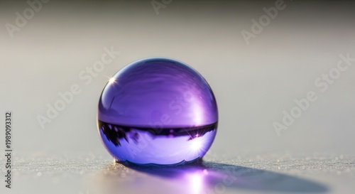 Vibrant purple sphere refracting light and inverting a subtle reflection on a textured surface