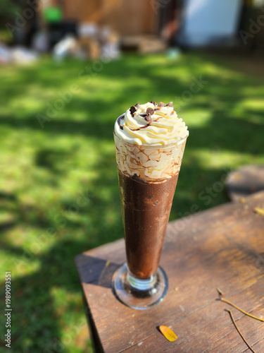 Iced Chocolate Drink with Whipped Cream on Wooden Table