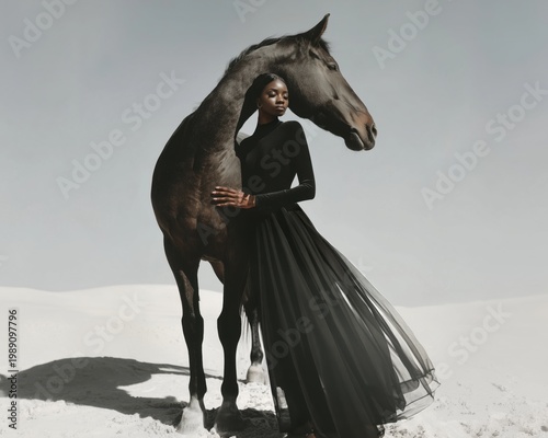 Elegant woman in black dress standing with a horse in a minimalist desert setting. Fashion and nature blend in a calm scene with soft light, artistic mood, modern style, beauty and strength concept.