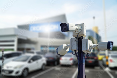 Several CCTV cameras are installed on the same pole in the parking lot,CCTV monitoring