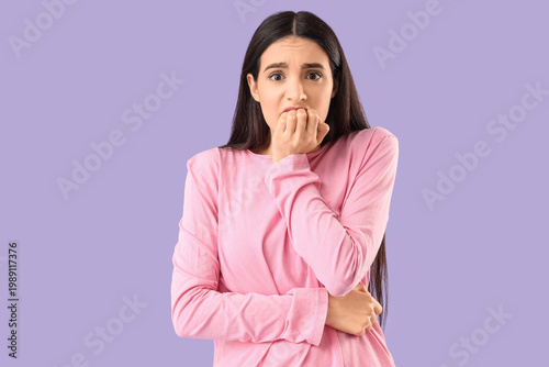 Scared young woman on lilac...