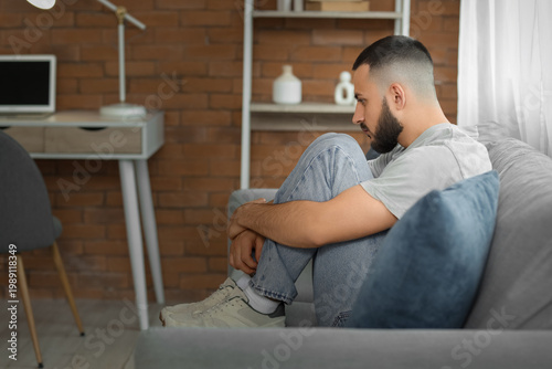 Depressed young man sitting...
