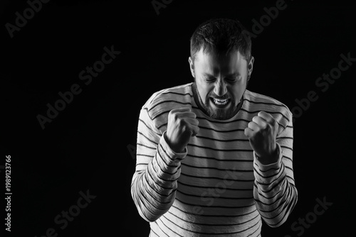 Screaming young man on blac...