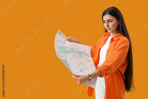 Young woman with map on yellow background. Search concept