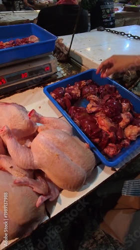 Video of a woman's hands selecting raw chicken livers and gizzards at a meat vendor's stand in a traditional market. Footage of shopping at a traditional Indonesian market in Steady 4K High Resolution