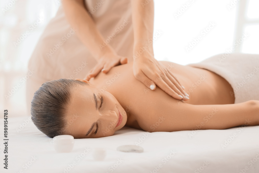 Obraz premium Young woman getting massage by therapist in spa salon
