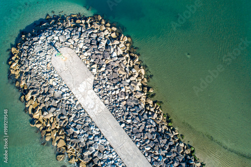 Εκτύπωση καμβά Aerial view of concrete breakwater in blue ocean water