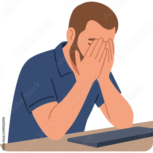 A man sits at a desk, covering his face with his hands in frustration while staring at a laptop.