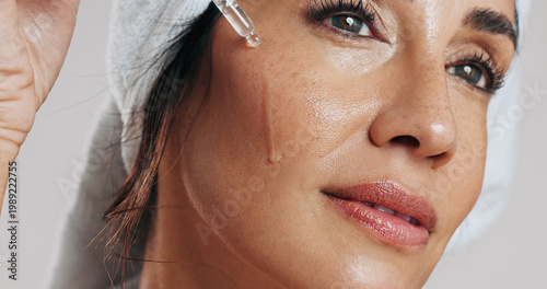 Photos Skincare, thinking or woman with serum in studio, apply hyaluronic acid or anti aging facial treatment
