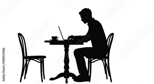 Man sitting at a small table working on laptop with a cup of coffee beside him