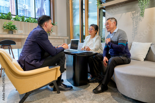 A couple senior people talking with businessman for business topic in co-working space office.