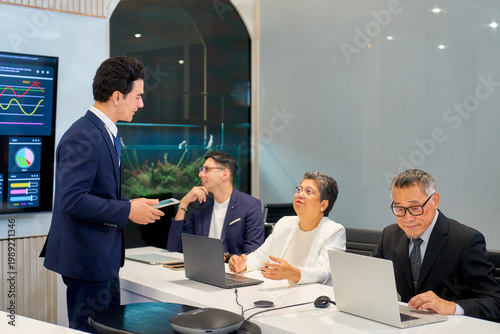 Scene of meeting room with businessman present to other person for graphic on screen.