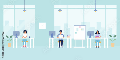 Modern office space with three people working at desks near windows