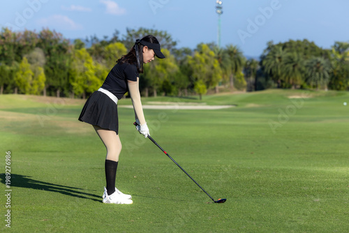 Konstfotografi Asian woman professional golfer play golf at golf course with green golf course background, Asian woman golf player swing tee off on the green, Healthy and Lifestyle