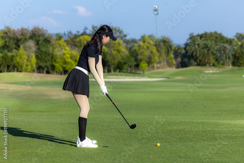 Konstfotografi Asian woman professional golfer play golf at golf course with green golf course background, Asian woman golf player swing tee off on the green, Healthy and Lifestyle