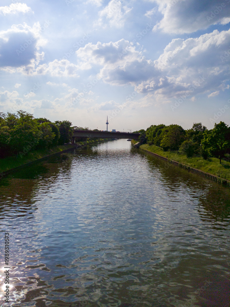 Fototapeta premium Serene river landscape with bridge and distant tower