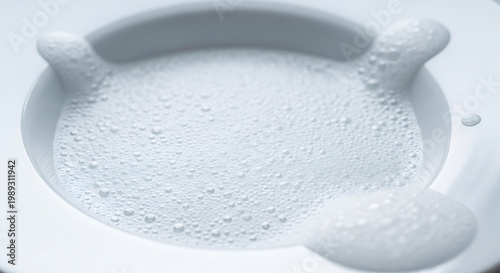 Close-up of freshly whisked white creamy foam, forming soft peaks and delicate bubbles within a pristine bowl, suggesting purity and lightness and a refreshing sensation
