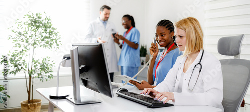 Foto Team of medical workers collaborating at a healthcare office while using technol