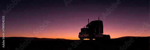 A silhouetted semi-truck stands prominently against a vibrant sunset sky, evoking a sense of travel and the open road.
